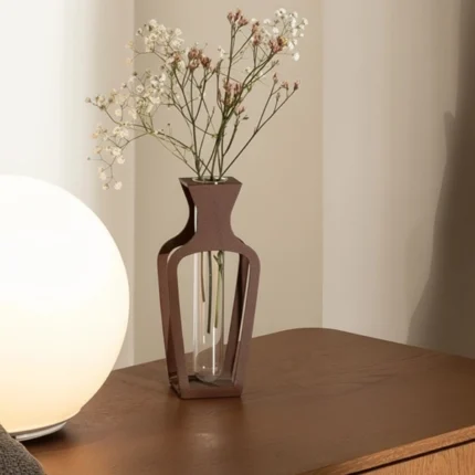 A modern take on floral display,Frame Vase . This metal decorative vase combines minimal design with industrial charm, featuring a sleek frame that holds a clear glass tube. Ideal for single stems or delicate arrangements, it adds a refined touch to any setting. (glass tube vase included)