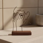 Hidden Grace a minimalist metal sculpture featuring an abstract human face profile, elegantly crafted with clean lines and subtle contours. The design evokes a sense of inner strength and quiet elegance, making it a timeless addition to any space. Ideal for: Modern living rooms, bedrooms, offices, or any area seeking a touch of understated sophistication.