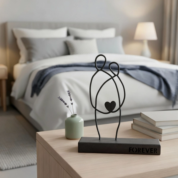 00141 decor7 A minimalist metal sculpture depicting two abstract human figures seated side by side, symbolizing unity and enduring connection. Its clean lines and subtle design evoke themes of companionship and togetherness. Ideal for: Living rooms, bedrooms, offices, or spaces celebrating love and unity.