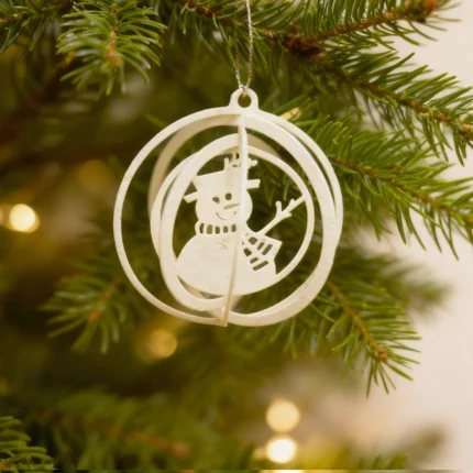 Halo Snowman Ornament. A playful yet minimal ornament from DIZE Art Objects, with a charming snowman set inside airy circular rings. Light-catching and warm, it brings a cheerful note to your festive setup.